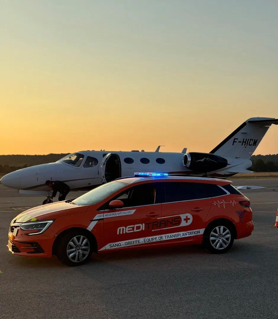 Véhicule de transport biomédical Meditrans et avion de transport sanitaire en arrière-plan